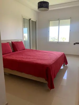 a bedroom with a large bed with a red blanket at Lovely apartment at Ola Blanca 2 with WiFi in Sidi Rahal