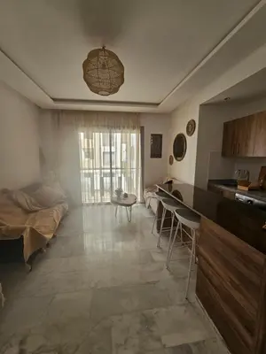 a kitchen and living room with a table and a bed at Airport Break in Nouaceur