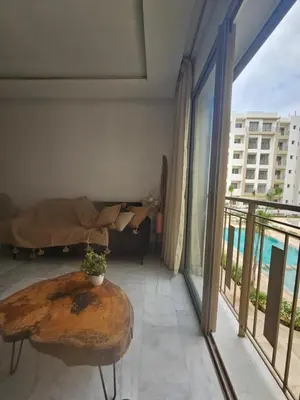 a living room with a couch and a table on a balcony at Airport Break in Nouaceur