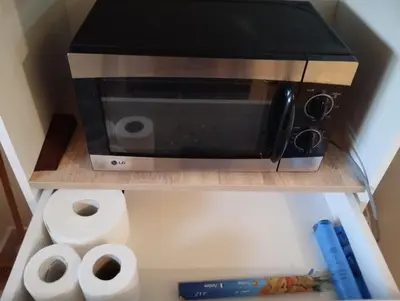 a microwave sitting on a shelf with toilet paper at Magnificent Sunlit Ground-Floor Apartment Netflix,Wi-Fi ,Comfort, Style in Casablanca