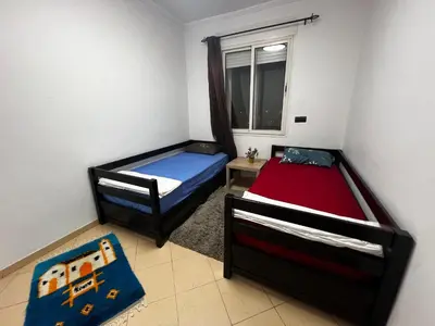 two beds in a small room with a window at Appart à 2 min de Casanearshore in Casablanca
