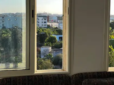 two windows in a room looking out at a city at Appart à 2 min de Casanearshore in Casablanca