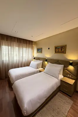 two beds in a hotel room with white pillows at Appart Hôtel Oleandro in Casablanca