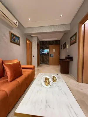 a living room with a couch and a table at Appart Hôtel Oleandro in Casablanca