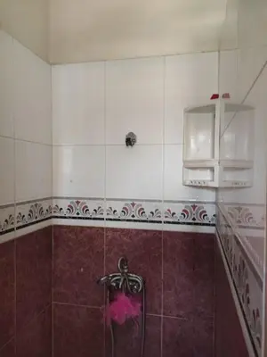 a bathroom with a shower with a pink flower on the tile at Villa à la décoration marocaine in Rabat