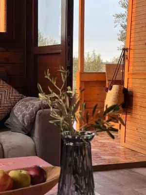 a vase sitting on a table with a bowl of fruit at Ecolodge Vert, Benslimane in Oulad Youssef