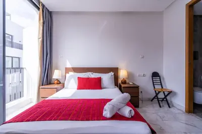 a bedroom with a large white bed with red pillows at New urban getaway 25 in Casablanca