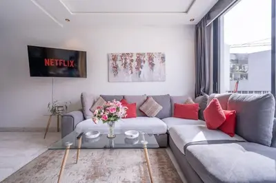a living room with a gray couch and red pillows at New urban getaway 25 in Casablanca