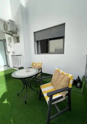 a room with two chairs and a table and a window at Central Holiday Apartment in Casablanca