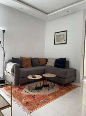 a living room with a couch and two tables at Central Holiday Apartment in Casablanca