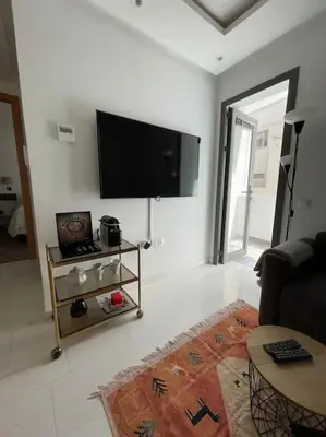 a living room with a flat screen tv on the wall at Central Holiday Apartment in Casablanca