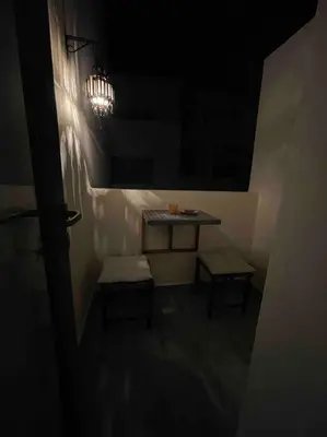 a dark room with a table and two benches at Central Holiday Apartment in Casablanca