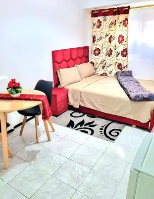 a living room with a bed and a table and a desk at Mi mini estudio 2 in Rabat