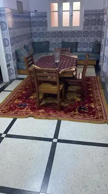a dining room with a table and chairs on a rug at Welcome Loc T4 in Casablanca