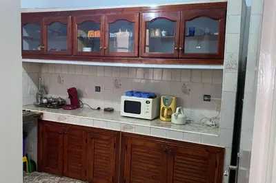 a kitchen with wooden cabinets and a microwave at Welcome Loc T4 in Casablanca