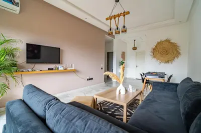 a living room with a blue couch and a table at AeroSerenity in Nouaceur