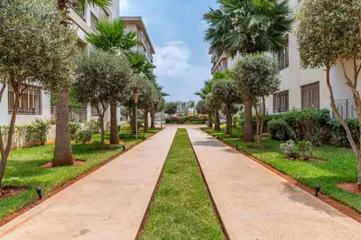 a walkway through a park with palm trees at AeroSerenity in Nouaceur