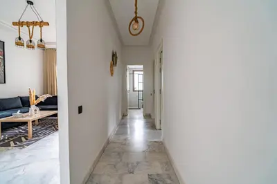 a hallway leading to a living room with white walls at AeroSerenity in Nouaceur