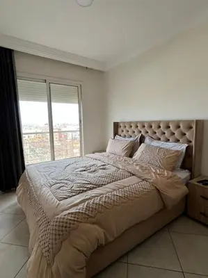 a bedroom with a large bed with a large window at appartement meublé in Mohammedia