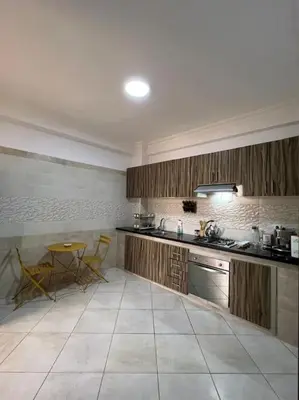 a kitchen with a sink and a table in it at appartement meublé in Mohammedia