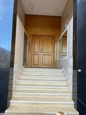 a staircase leading to a wooden door in a building at appartement meublé in Mohammedia