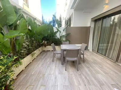 a table and chairs on a patio with plants at Corniche Casablanca- Golden Hour in Casablanca