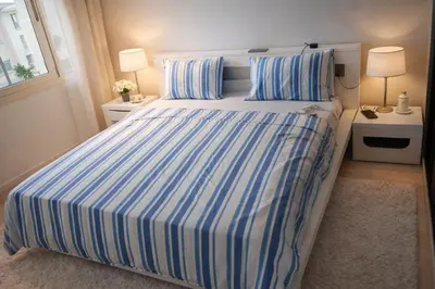 a bedroom with a large bed with blue and white stripes at Appart Residence Haut Standing in Bouznika