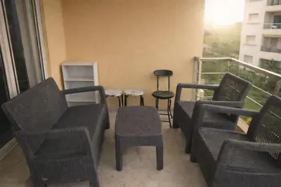 a balcony with chairs and tables on a balcony at Appart Residence Haut Standing in Bouznika