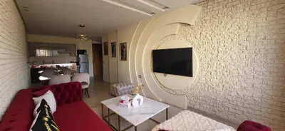 a living room with a red couch and a wall at Le Bijou du Maarif in Casablanca