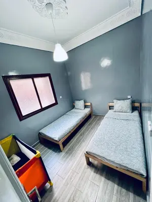 a room with two beds and a window at Appartement très équipé etpropre 1 in Camp de Mediouna