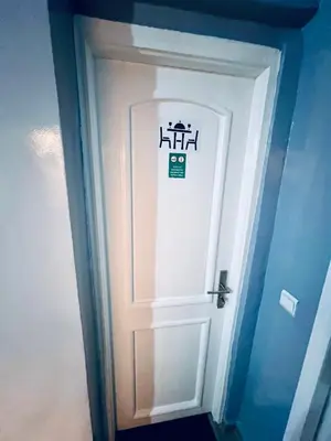 a white door with a sign on it in a room at Appartement très équipé etpropre 1 in Camp de Mediouna