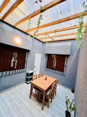 a patio with a wooden table and chairs at Appartement très équipé etpropre 1 in Camp de Mediouna