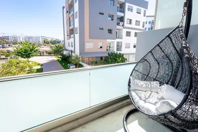 a hammock on a balcony with a view of a city at Appartement Duplex G1 in Casablanca