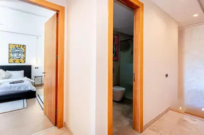 a bedroom with a bed and a door to a bathroom at Appartement Duplex G1 in Casablanca