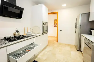 a white kitchen with a stove and a refrigerator at Appartement Duplex G1 in Casablanca