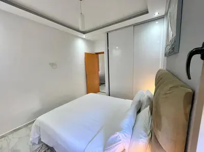 a bedroom with a white bed and a mirror at A2 Luxe Moderne et Confort, 7 min du Stade Moulay Abdellah in Temara