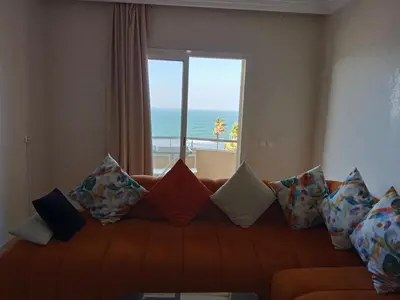 a couch with pillows in a room with a window at Appart 3p vue sur mer in Rabat