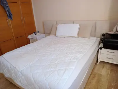 a bedroom with a large bed with a white comforter at Appart 3p vue sur mer in Rabat