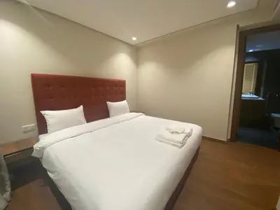 a bedroom with a large white bed with two towels on it at Hilbert Princesses - Furnished apartments in Casablanca