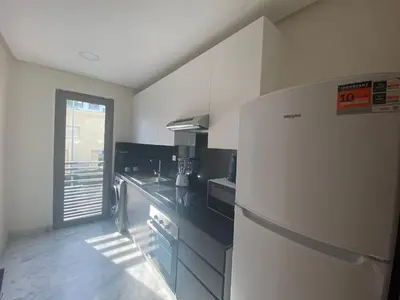 a kitchen with a refrigerator and a counter top at Hilbert Princesses - Furnished apartments in Casablanca