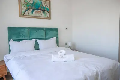 a large white bed with a towel on it at Magnificient Appartment in Prestigia in Rabat
