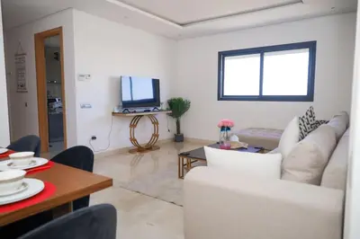 a living room with a white couch and a table at Magnificient Appartment in Prestigia in Rabat