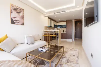 a living room with a white couch and a table at Maarif princess amazing one bedroom flat in Casablanca