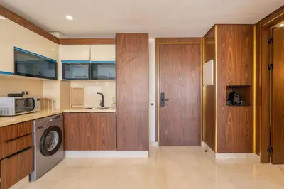 a kitchen with wooden cabinets and a washing machine at Maarif princess amazing one bedroom flat in Casablanca