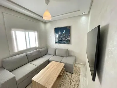 a living room with a couch and a table at A3 Luxe and Cosy Apartement, 7 min du Stade Moulay Abdellah in Temara