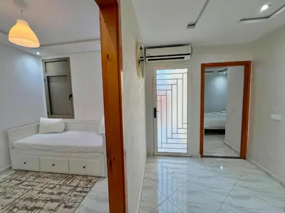 a bedroom with a bed and a mirror at A3 Luxe and Cosy Apartement, 7 min du Stade Moulay Abdellah in Temara