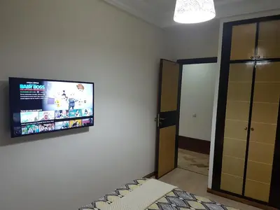a bedroom with a flat screen tv on the wall at High-End Apartment with Terrace in Val Fleuri, Maarif Casablanca, Ideal for Families & Business Travelers in Casablanca