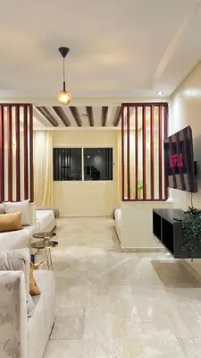 a living room with a couch and a tv at SUITOUISS - Agdal 1 - Appartement à 2 minutes de la gare de train TGV Rabat in Rabat