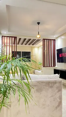 a hotel room with a bed and a plant at SUITOUISS - Agdal 1 - Appartement à 2 minutes de la gare de train TGV Rabat in Rabat