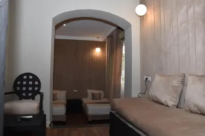 a room with a bed and a chair and a mirror at Cadé Hotel in Casablanca